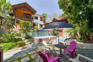 a table with chairs and an umbrella on a patio at Villa Bayacanes con piscinas privadas in Jarabacoa