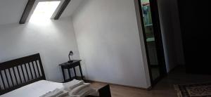 a bedroom with a bed and a lamp on a table at Pensiunea Gradinarilor cu ciubăr și stație de încărcare electrică auto in Comăneşti