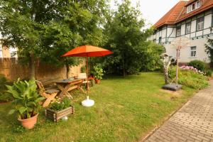 una mesa de picnic con una sombrilla en un patio en Ferienwohnung Hoff, en Göllingen