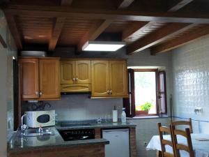 eine Küche mit Holzschränken und einer Arbeitsplatte in der Unterkunft Casa Adela El Tuxu in Perlleces