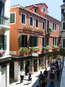 un grupo de personas caminando por una calle frente a un edificio en Hotel Da Bruno, en Venecia