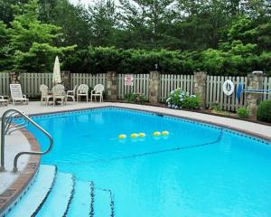 een groot blauw zwembad met stoelen en een hek bij Peaceful treetop escape! Pool table, grill, games, sleeps 10! in Helen