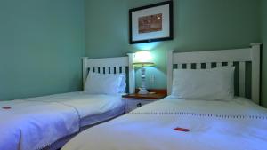 two beds sitting next to each other in a room at D'Aria Guest Cottages in Durbanville