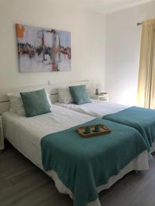 a bedroom with two beds with a tray on it at Quinta do Lago Golf, Sea & Sun in Quinta do Lago