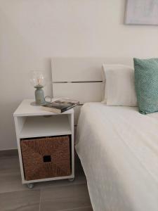 un letto con comodino accanto a un letto bianco con tavolino. di Quinta do Lago Golf, Sea & Sun a Quinta do Lago