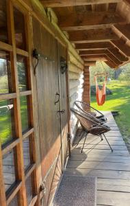 un porche con un columpio y una puerta a una cabaña en Sepasaun, en Joaveski
