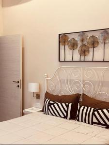 ein Schlafzimmer mit einem Bett und einem Bild von Sonnenschirmen in der Unterkunft B&B Meliora Rooms in Avola