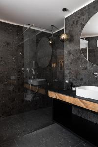 bagno con lavandino e doccia in vetro di Alpuris - Your Boutique Suite - Hotel B&B a Cavalese