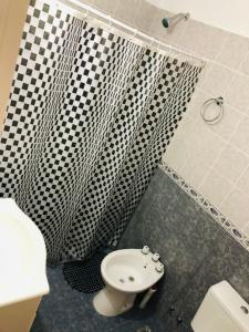 a bathroom with a black and white shower curtain and a toilet at ZR Playa Union in Playa Unión