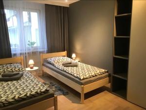2 łóżka w małym pokoju z oknem w obiekcie Mieszkanie Osiedle Slichowice, Targi Kielce 3,5km, faktury VAT w Kielcach