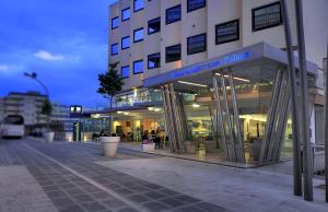 a building on a street in front of a building at Mediterraneo Palace Hotel in Ragusa