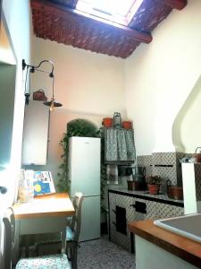 una cucina con frigorifero, tavolo e piano cottura di Adeste 41 a Scicli