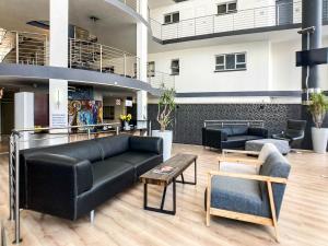a lobby with couches and tables in a building at Splice Apartments in Johannesburg