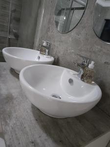 bagno con lavandino bianco e specchio di EYEZULU Guesthouse a Pinetown