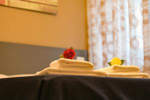 two towels with a strawberry on top of a table at ALMA B&B Home Cosenza in Cosenza
