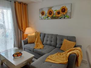 a living room with a couch and a table at Jacuzzi House Sunflower in Costa Del Silencio