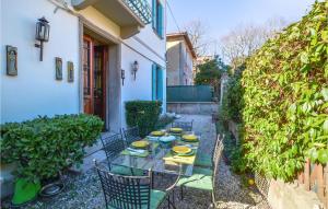 Amazing Home In Lido Di Venezia With Kitchen في ليدو دي فينيتسا: فناء فيه طاولة عليها صحون صفراء