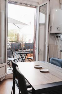 une table à manger avec des chaises et une vue sur un balcon. dans l'établissement R'Apparts T2 Au Grenoblois Dormant, à Grenoble
