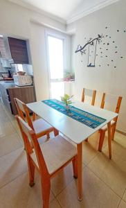 a dining room table with chairs and a white table at Departamento Albaluz Barrio Sur in San Miguel de Tucumán