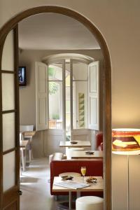 a dining room with tables and chairs and a mirror at Hotel Mar de Tasmània - Auto Check-in in La Bisbal