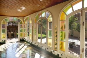an empty hallway with stained glass windows in a house at Hotel Mar de Tasmània - Auto Check-in in La Bisbal