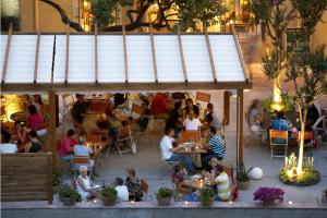 a group of people sitting at tables in a restaurant at Hotel Mar de Tasmània - Auto Check-in in La Bisbal
