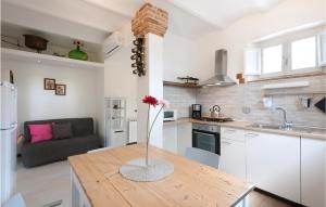 una cucina con tavolo e vaso di fiori di Beautiful Home In Arcevia With House A Panoramic View ad Arcevia