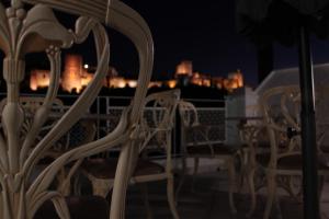 un grupo de sillas sentadas en un balcón por la noche en Suite Comares en Granada
