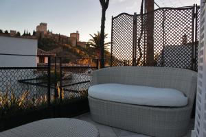 
a white couch sitting in front of a fence at CANDIL SUITE Comares in Granada
