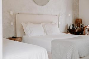 a bedroom with two beds with white sheets at Ponte Pedra Melides -Nature & Ocean- Adults Only in Melides