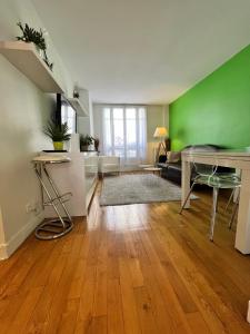 a living room with green walls and a wooden floor at Amazing apartment 1BDR2PAX PARIS Boulogne Roland Garros in Boulogne-Billancourt