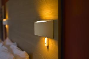 un interruptor de luz en una pared junto a una cama en Piccadilly Hotel en Bournemouth