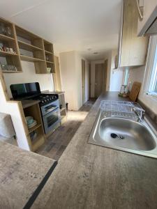 a kitchen with a large sink in the middle at Modern & Homley 3BR Caravan in Hastings