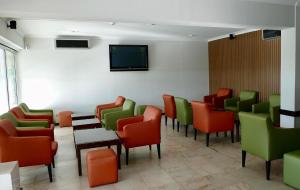 a waiting room with colorful chairs and a tv at Parque Mourabel, Oásis Village & Pé do Lago in Vilamoura