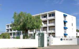 a white building with a tree in front of it at Parque Mourabel, Oásis Village & Pé do Lago in Vilamoura