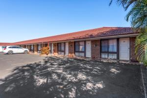 a building with a car parked in a parking lot at Bomaderry Motor Inn in Nowra