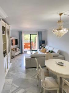 ein Wohnzimmer mit einem Sofa und einem Tisch in der Unterkunft Marbella Cabopino golf and beach only Adults in Marbella