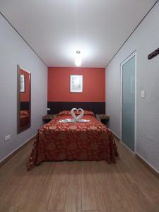 1 dormitorio con 1 cama con pared roja en Hotel Teresita, en Puebla