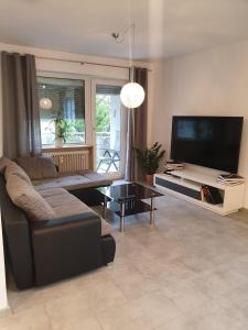 a living room with a couch and a flat screen tv at Casa Joda in Hügelsheim