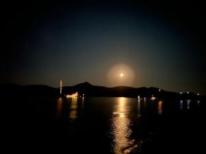 a moon rising over a body of water at night at KAMEO, Antiparos in Antiparos