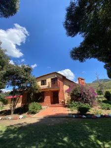 a large brick house with a large driveway at BS HOTEL CAMPESTRE in Cucunubá