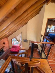 una sala de estar con una escalera de madera en una casa en BS HOTEL CAMPESTRE, en Cucunubá