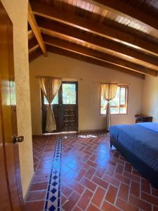 1 dormitorio con 1 cama, 2 ventanas y puerta en BS HOTEL CAMPESTRE, en Cucunubá
