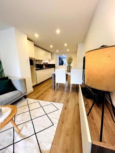 a kitchen and living room with a table and chairs at Sfeervolle vakantiewoning aan zee in Ostend