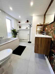 La salle de bains est pourvue d'une baignoire, de toilettes et d'un lavabo. dans l'établissement Sfeervolle vakantiewoning aan zee, à Ostende