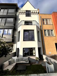 a white building with a couch in front of it at Sfeervolle vakantiewoning aan zee in Ostend