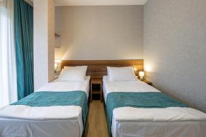 Una cama o camas en una habitación de Hotel GENI Kazbegi
