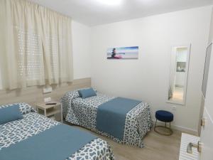 um quarto com duas camas e um espelho em Coliseo Albir Beach em Albir