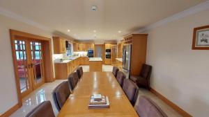 una grande sala da pranzo con un lungo tavolo e sedie di Drumsallagh View a Loughbrickland