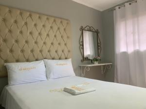 um quarto com uma cama branca e uma grande cabeceira de cama. em Glamour Hotel em La Romana